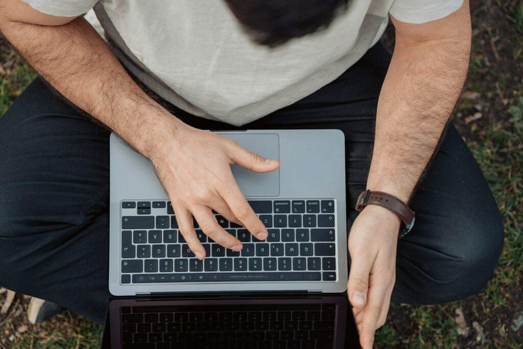 person in white shirt using macbook pro