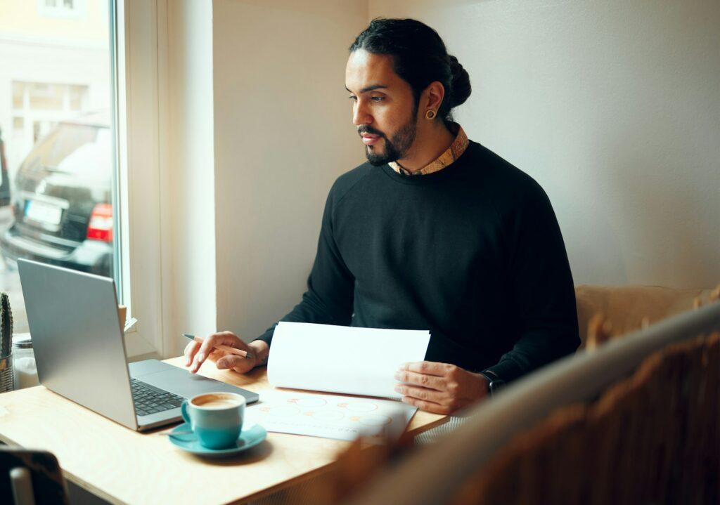 Startup, research or business man on laptop in coffee shop for strategy planning, life insurance or