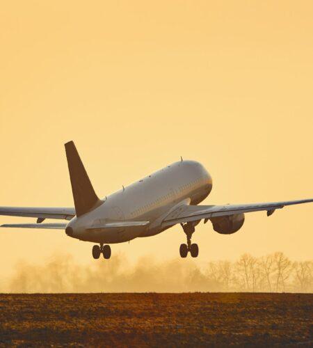 Airplane taking off at sunset